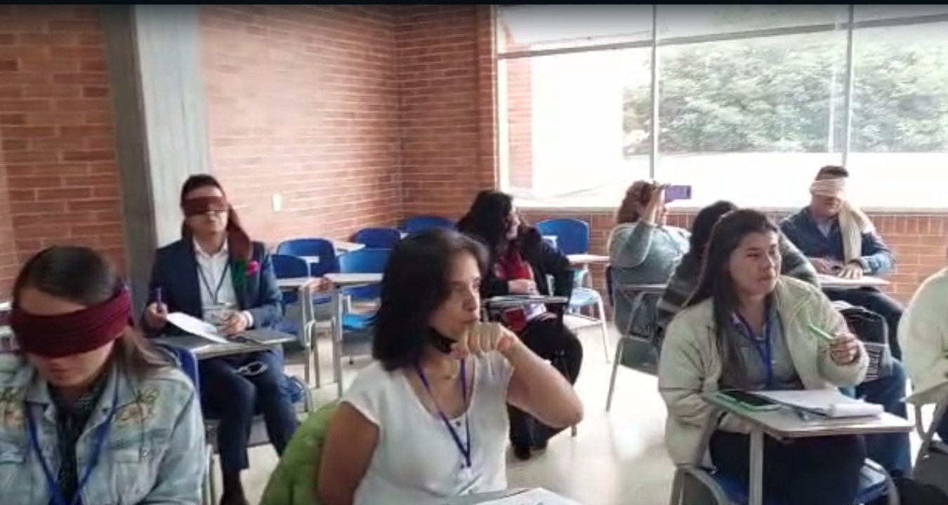 Profesores sentados en salón de clases, realizando taller de inclusión. Dirigidos por Juan Carlos Ortiz